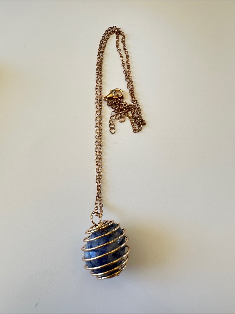 Gold Spiral Cage Necklace with Blue Stone Pendant
